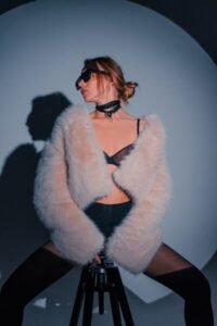 Woman in faux fur coat and sunglasses posing