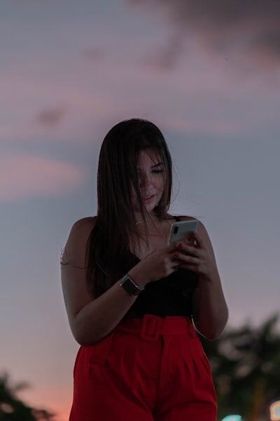 a woman in red shorts looking at her cell phone