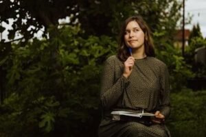 A woman sitting on a bench holding a blue toothbrush