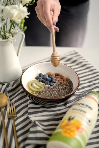 a bowl of oatmeal with blueberries, bananas, and a honey