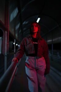 Woman standing in dimly lit tunnel with red light