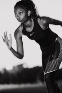 A woman in black and white running with a tennis racket