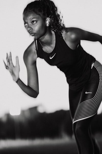 A woman in black and white running with a tennis racket