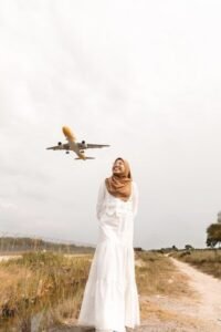 Woman in hijab watches airplane approach