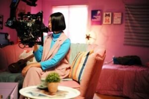 a woman sitting on a couch holding a camera